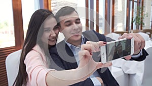 Couple in love at restaurant making selfie on a smartphone stock footage video