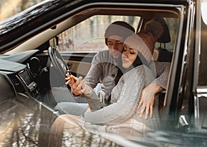 Couple in love resting in car in the forest