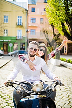 Couple in love riding a motorbike. Young riders enjoying themselves on trip.