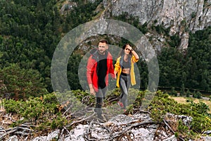 A couple in love on a rock admires the beautiful views. A man and a woman on a rock. A couple in love travels.