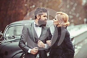 Couple in love on romantic date. Bearded man and sexy woman in fur coat. Retro collection car and auto repair by