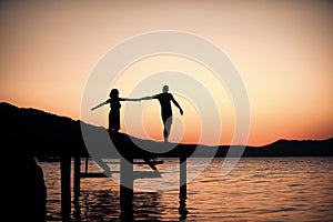 Couple in love on romantic date in evening at dock, copy space. Romance and love concept. Silhouette of sensual couple