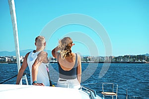 Couple in love on a sail boat yacht in the summer holiday vacation looks at the horizon into future.