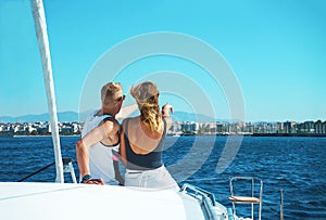 Couple in love on a sail boat yacht in the summer holiday vacation looks at the horizon into future.