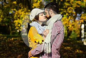 Couple in love with scarves holds yellow leaf