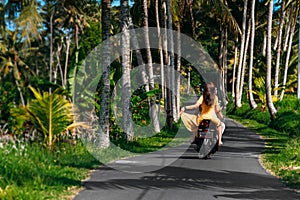 A couple in love on a scooter among the palm trees. Happy couple on vacation in Sri Lanka. The couple travels the world. Vacation