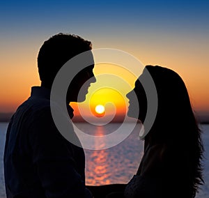 Couple in love silhouette at lake sunset