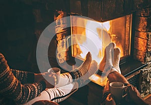 Couple in love sitting near fireplace. Legs in warm socks close