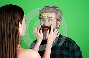 Couple in love with spa cucumber mask, beauty concept healthy portrait. Mud facial mask, face clay mask spa. Man and