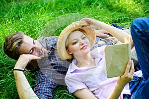 Couple in love spend leisure reading book in park. Man and girl lay on grass reading book. Family enjoy leisure with