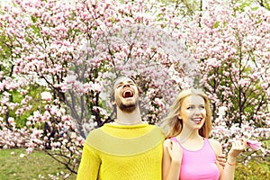 Couple in love in spring magnolia flowers, happy man, woman