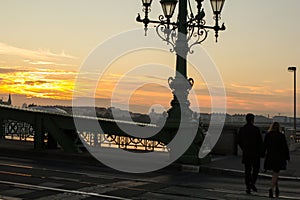 Couple in love is standing on the liberty bridge over the river Danube in Budapest. Sunrise in the big city. Man and woman are