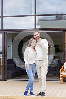 Couple in love standing on terrace of new house