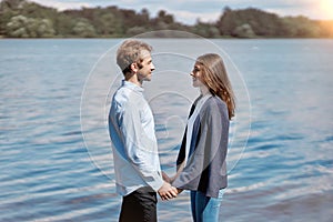 couple in love standing together on the shore of the lake .