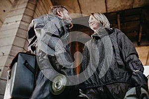 Couple in love stands in NBC protective suits and gas masks in their hands