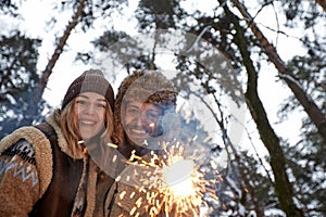 Couple Love Story in Snow Forest Kissing and Holding Sparklers. Couple in Winter Nature. Couple Celebrating. Valentine& x27;s