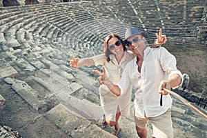 Couple in love take a selfie photo in ancient amphitheater in th