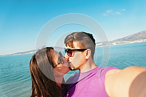 Couple in love taking self-portrait on beach