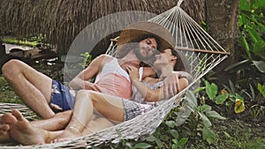 Couple in love talking, relaxing on hammock