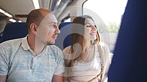 A couple in love traveling in the elektro train looking through the window at the surroundings.