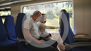 A couple in love traveling in the elektro train looking through the window at the surroundings.