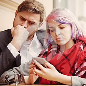 Couple in love while traveling monitoring their stock prices remotely with smart phone