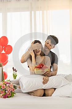 Couple, Love and Valentine`s Day Concept. Portrait of two smiling asian man surprised and close woman eye with gift box and