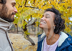 Couple in love are walking in the autumn park. Afroamerican girl with a European