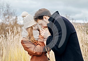 Couple in love walking in the autumn Park, cool fall weather. A man and a woman embrace and kiss, love and affection yellow autumn