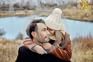 Couple in love walking in the autumn Park, cool fall weather. A man and a woman embrace and kiss, love and affection yellow autumn