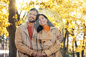 Couple in love walking on autumn park, enjoying a beautiful autumn day