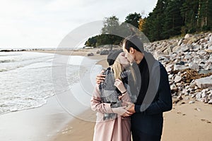 Couple in love walking on the beach, hugging and kissing.