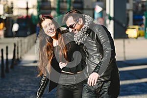 Couple in love walking casually embraced and laughing with loud laughter