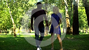 Couple in love walking in forest, interracial relationship romantic outdoor date