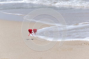 Couple in love walking on sea beach washed by wave. Two hearts on sea coast. valentine card, summer holidays background