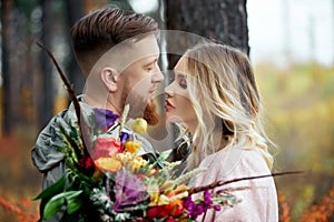 Couple in love walks through autumn forest. Hugs and kisses of men and women, relationships and love. Young couple stands in