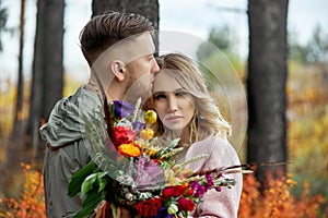 Couple in love walks through autumn forest. Hugs and kisses of men and women, relationships and love. Young couple stands in