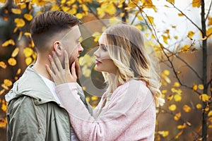 Couple in love walks through autumn forest. Hugs and kisses of men and women, relationships and love. Young couple stands in