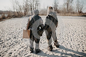 Couple in love walks at beach in NBC protective suits