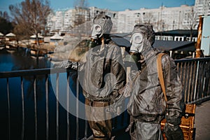 Couple in love walks at bridge and holds hands in NBC protective suits and gas masks