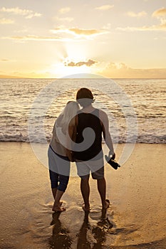 Couple in love watching a sunset at the beach together