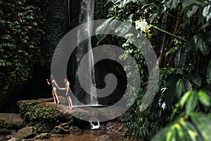 A couple in love on a waterfall. Honeymoon trip. Happy couple on the island of Bali. Beautiful couple travels the world.