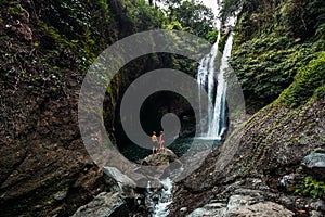 A couple in love on a waterfall. Honeymoon trip. Happy couple on the island of Bali. Beautiful couple travels the world. Travel