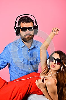 Couple in love wears plastic headphones and sunglasses