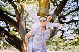 Couple in love woman riding on back of man at park,Romantic and enjoying in moment of happiness time,Happy and smiling,Positive th