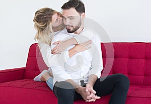 Couple in lover girlfriend hugging her boyfriend on couch in living room,Loving everything together,Happy and smiling