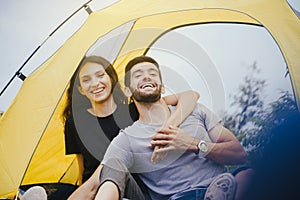 Couple lover hugging together sitting in tent feeling happy and smiling,Enjoying camping