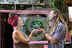 Couple of loving hippies taking little green plant to their home