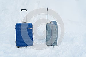 Couple Luggage Suitcase with Snow, Tourist dragging Baggage during walking on snowy walkway. Winter travel, Journey and Vacation