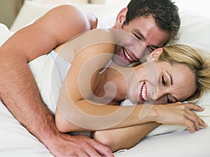 Couple lying in bed laughing